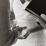 black and white photo of the couple exchanging rings.