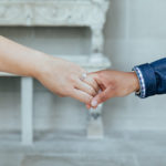 closeup of brides to be holding hands and engagement ring.