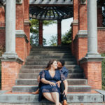 shot of brides sharing a kiss, sitting on steps if italian gardens at vanderbilt mansion.