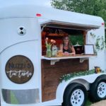a photo of the owner sitting inside of the mobile tavern.