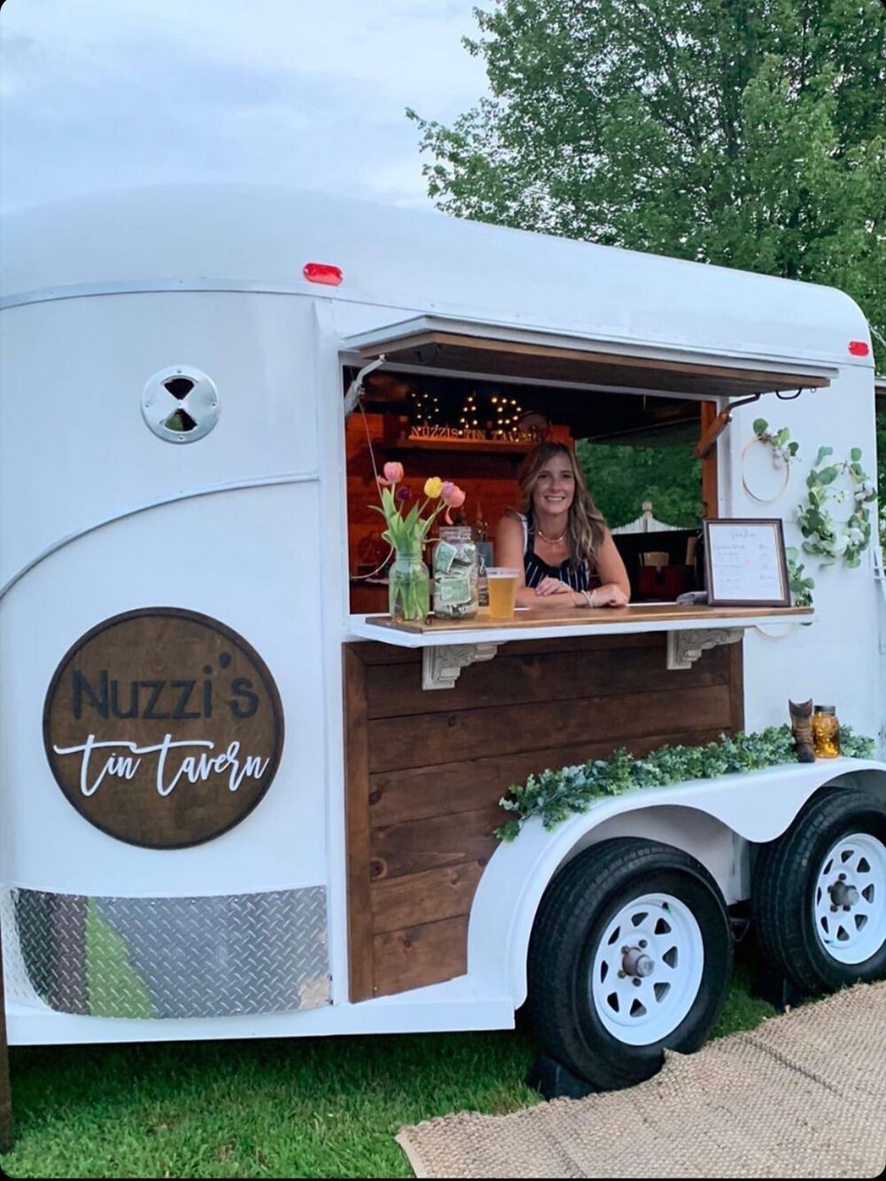 a photo of the owner sitting inside of the mobile tavern.