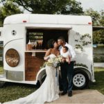 photo of a bride anf groom sharing a kiss out in front of the mobile tavern. New Wave of Mobile Wedding Services