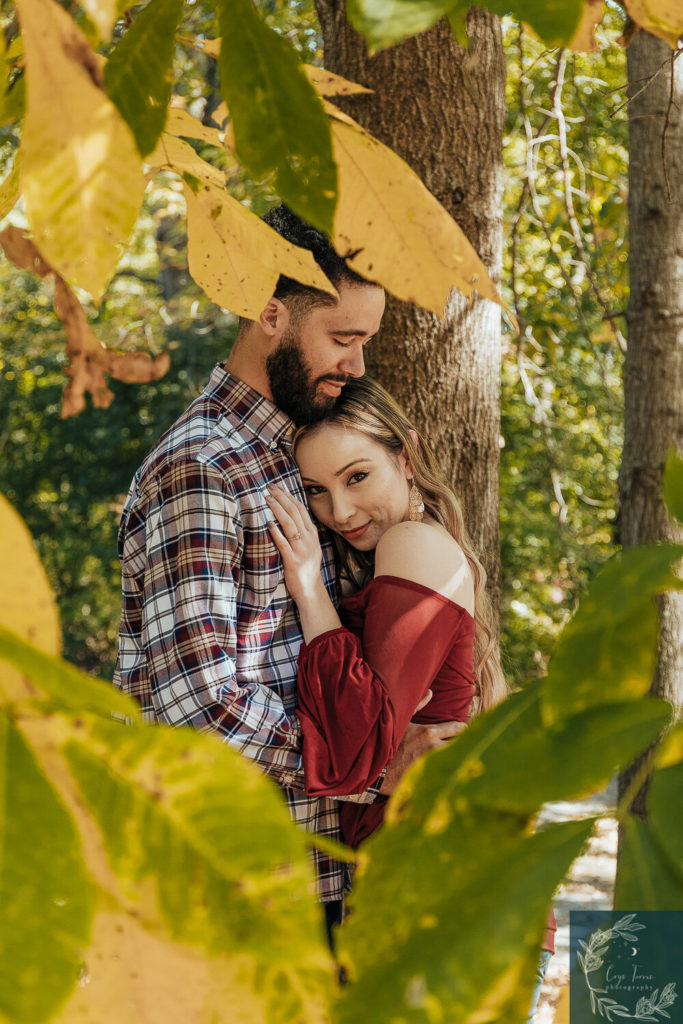 newly engaged couple shares an intimate embrace among the fall leaves.