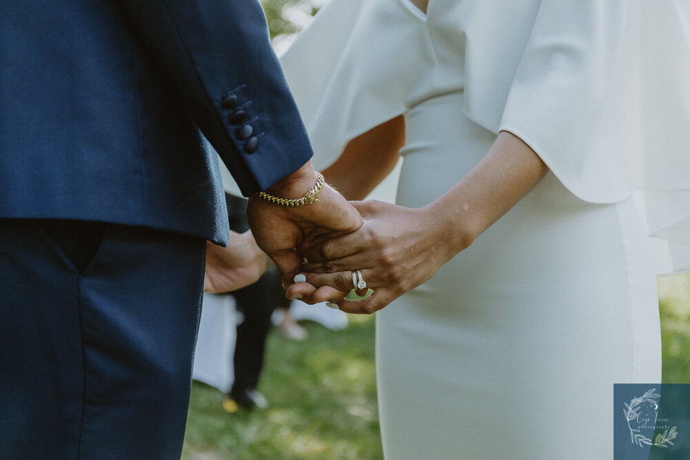 a closeup of the bride and groom's hands.