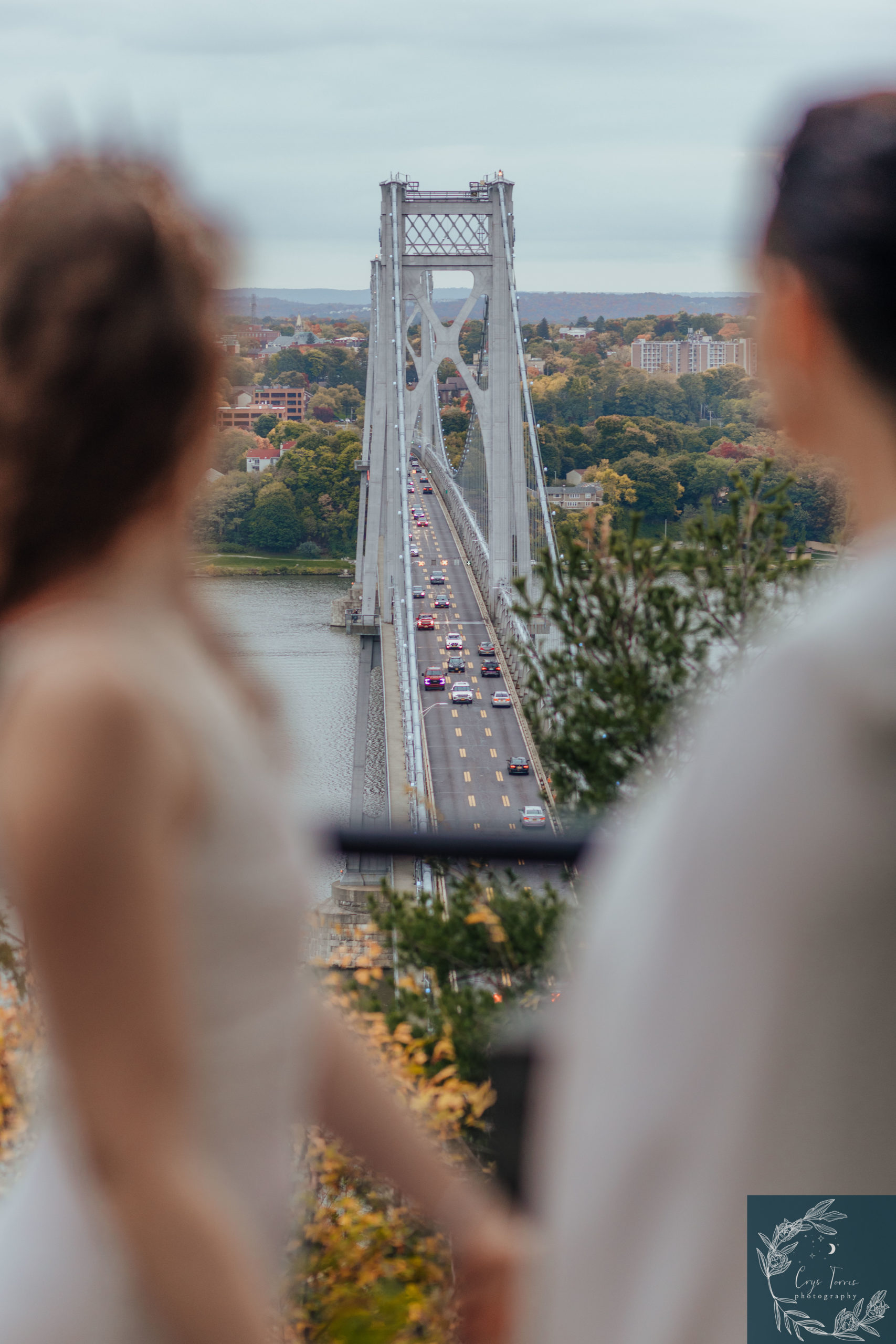 how to elope in New York. couple stands at lookout point an takes in the view of the mid-hudson bridge