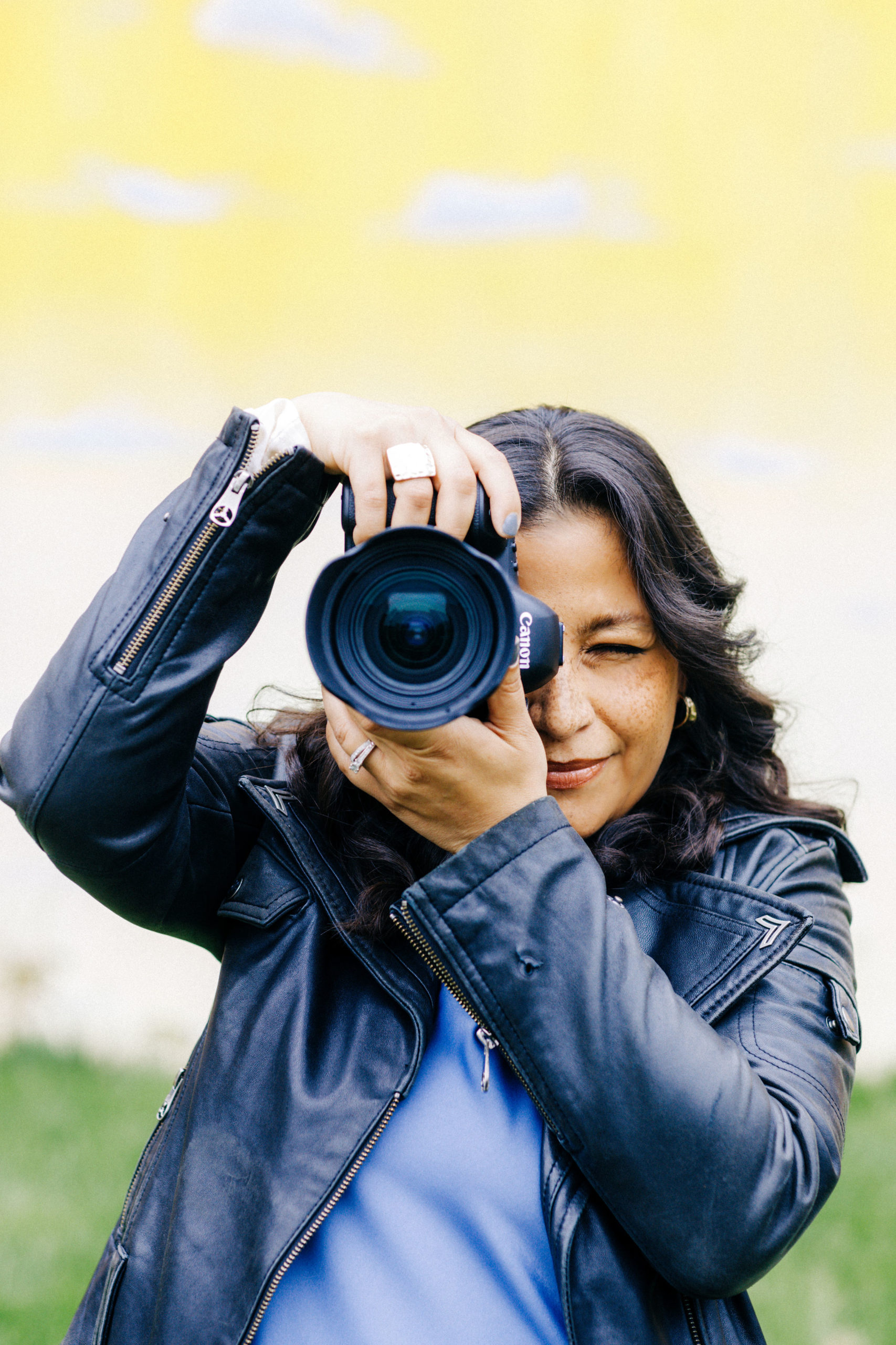 Crystal Torres Photographer holds camera up to shoot a photo.