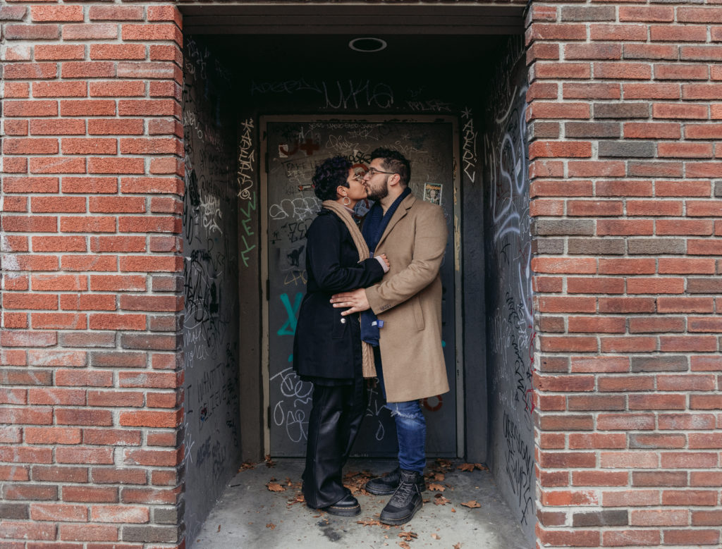 couple sharing a kiss in doorway in kingston new york