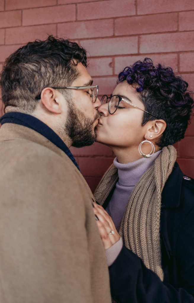 close up of newly engaged couple shgaring a kiss. lgbtq engagement