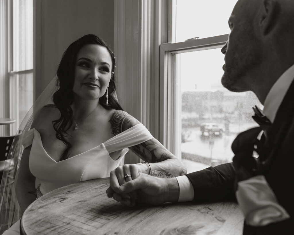 black and white portrait of bride smiling at groom.